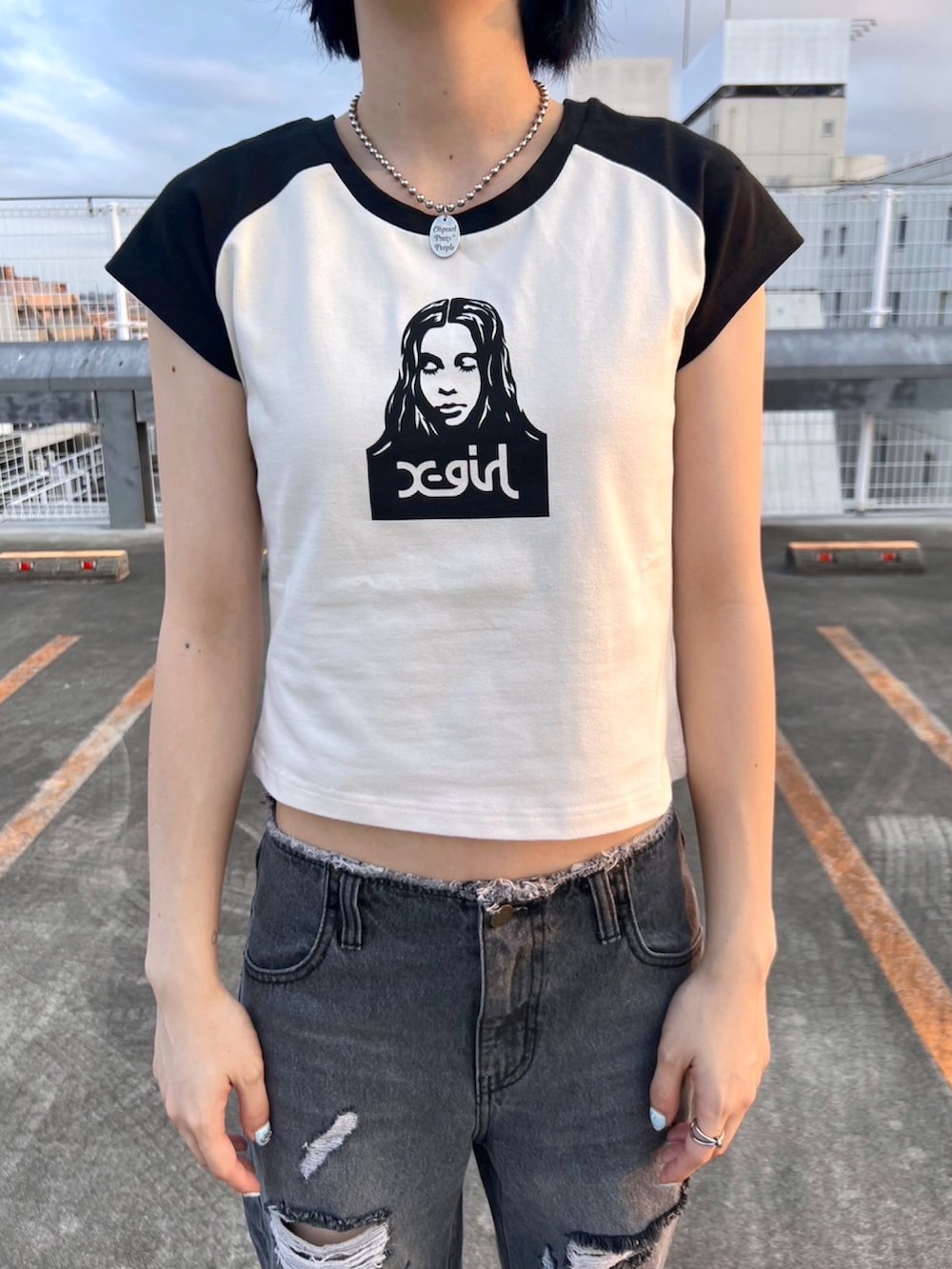 ブラック系のデニムパンツ、ホワイト系のTシャツ/カットソー、ブラック系のキャップを着用したレディースの夏コーディネートの3枚目の写真