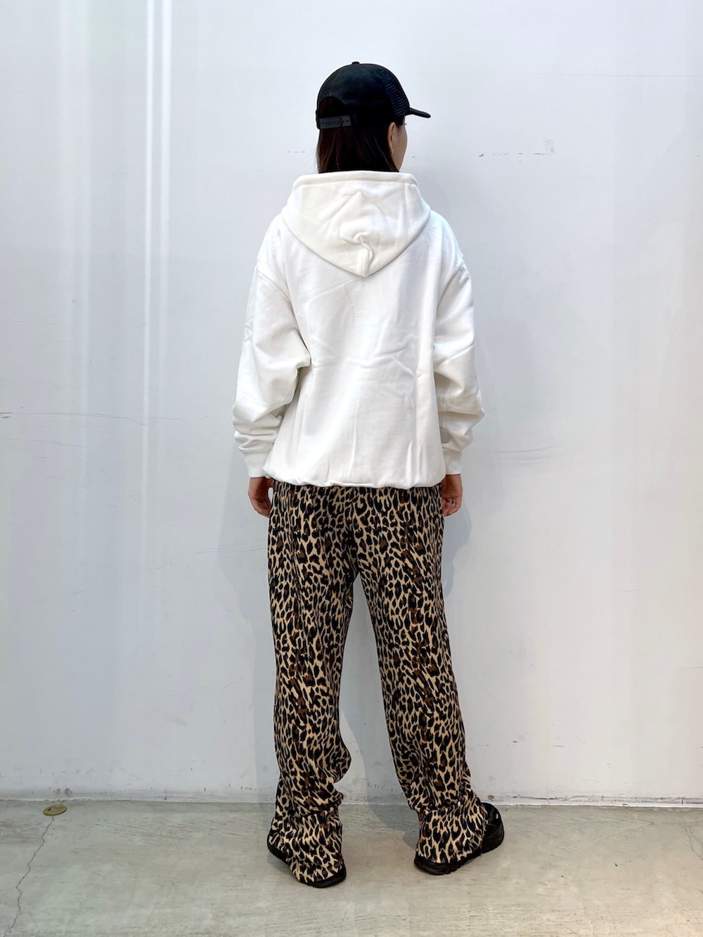 ベージュ系のその他パンツ、ホワイト系のパーカー、ブラック系のキャップを着用したレディースの秋コーディネートの2枚目の写真