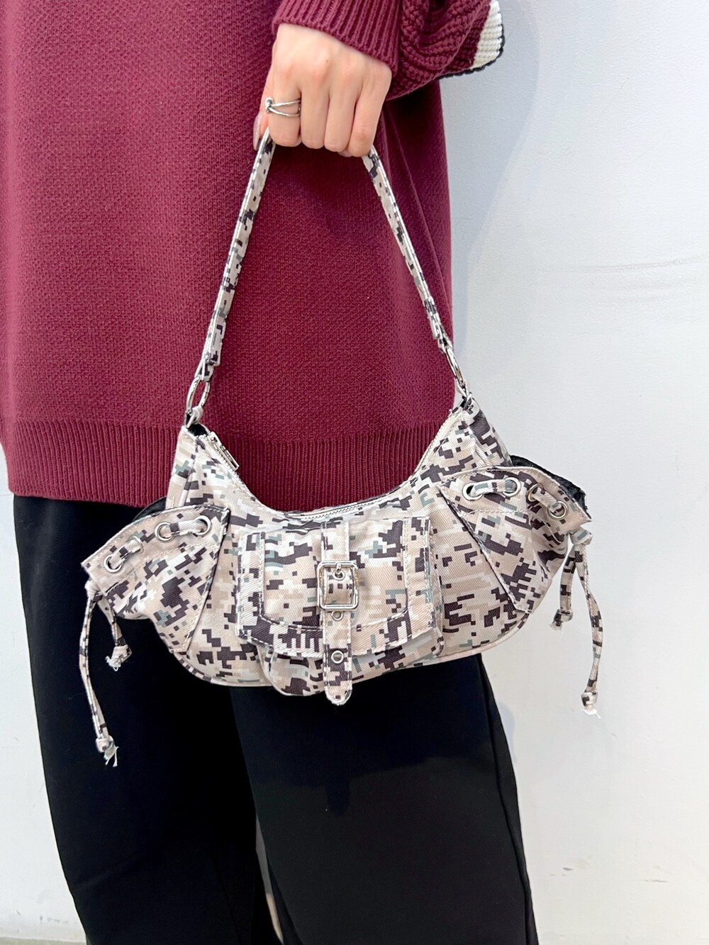 レッド系のニット/セーター、ブラック系のスウェットパンツ、ベージュ系のハンドバッグを着用したレディースの冬コーディネートの7枚目の写真