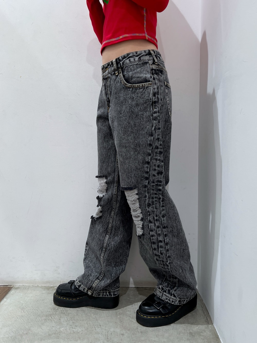 ブラック系のデニムパンツ、レッド系のTシャツ/カットソー、ブラック系のキャスケットを着用したレディースの秋コーディネートの5枚目の写真