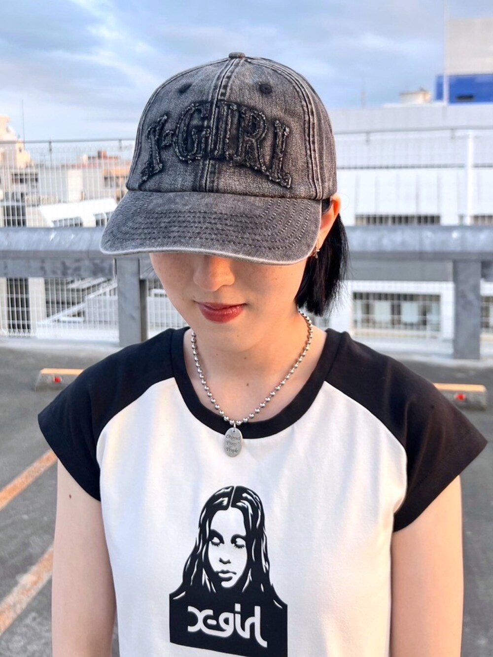 ブラック系のデニムパンツ、ホワイト系のTシャツ/カットソー、ブラック系のキャップを着用したレディースの夏コーディネートの6枚目の写真