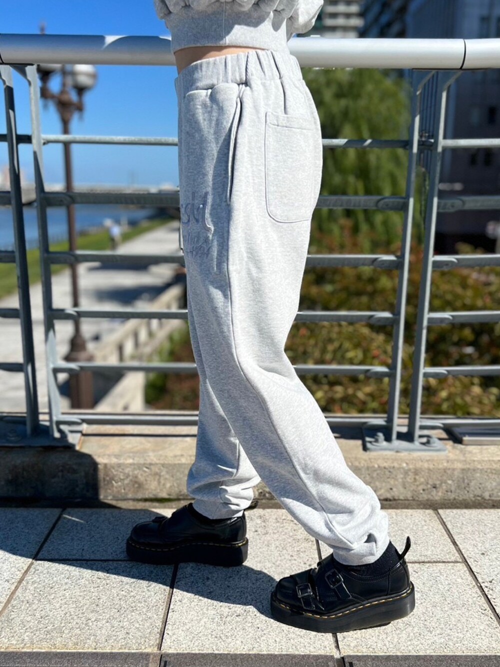 グレー系のスウェットパンツ、グレー系のパーカー、ブラック系のスタジャンを着用したレディースの秋コーディネートの5枚目の写真