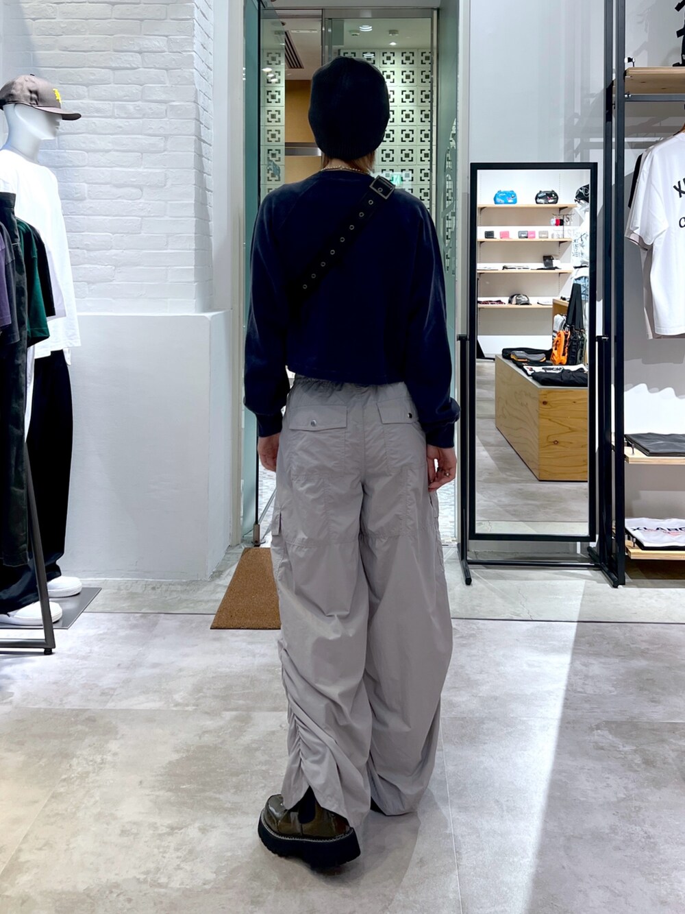 ブラック系のショルダーバッグ、グレー系のカーゴパンツ、ブルー系のスウェットを着用したレディースの夏コーディネートの2枚目の写真