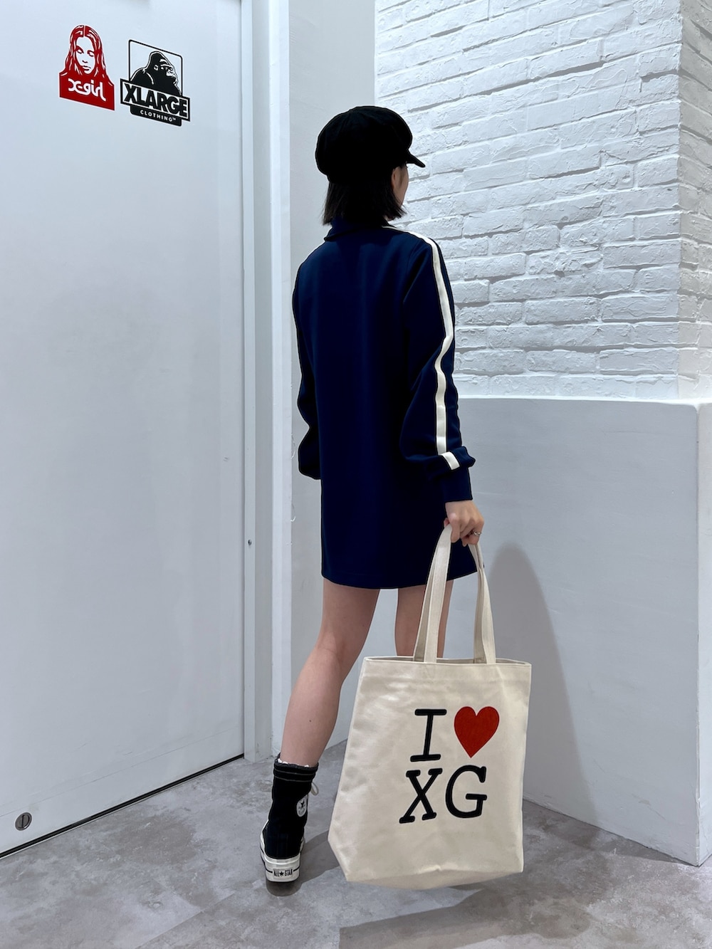 ブルー系のワンピース、ホワイト系のトートバッグ、ブラック系のキャスケットを着用したレディースの秋コーディネートの2枚目の写真