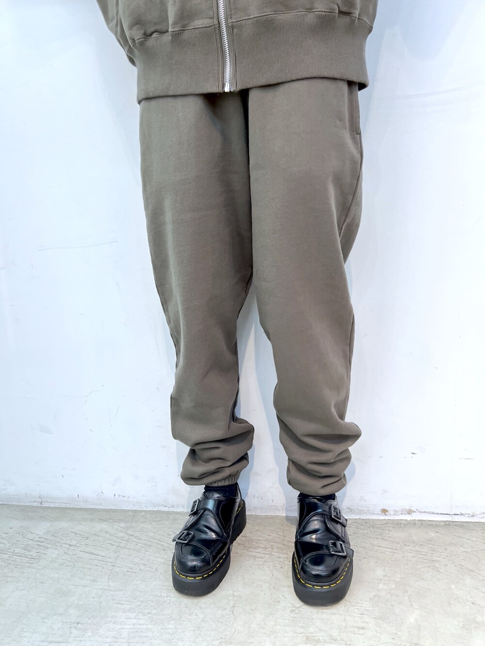 ブラック系のショルダーバッグ、グリーン系のスウェット、グリーン系のスウェットパンツを着用したレディースの冬コーディネートの4枚目の写真