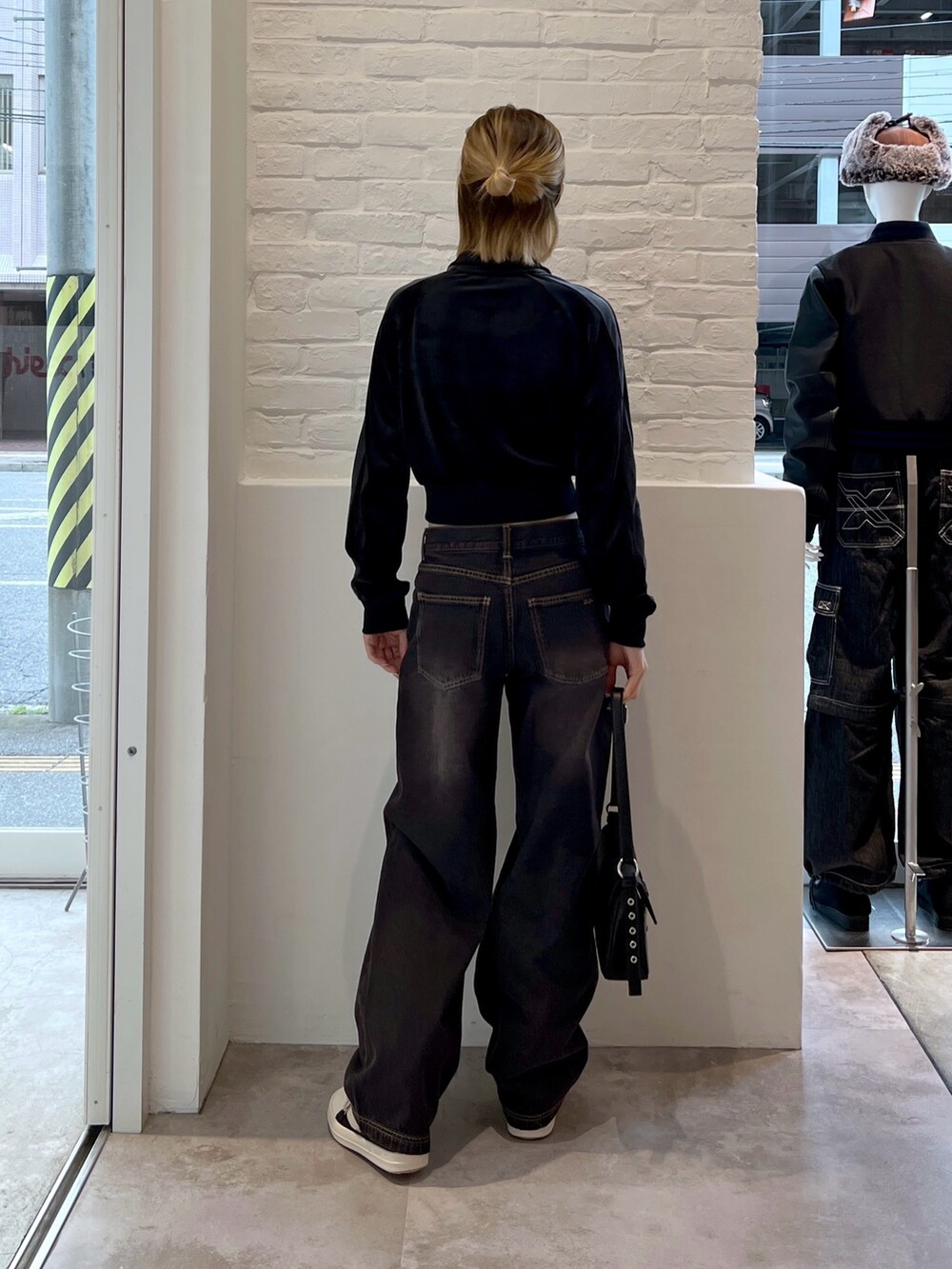 ブラック系のブルゾン、ブラック系のショルダーバッグ、ブラック系のデニムパンツを着用したレディースの秋コーディネートの3枚目の写真