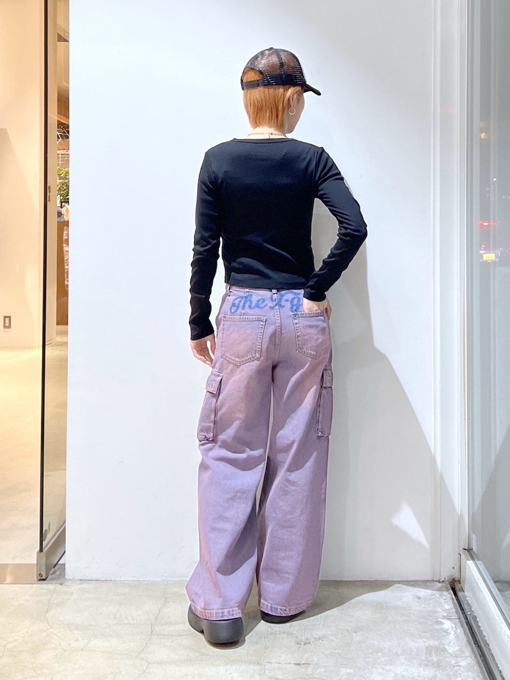 ピンク系のデニムパンツ、ブラック系のTシャツ/カットソー、ブラック系のキャップを着用したレディースの冬コーディネートの2枚目の写真