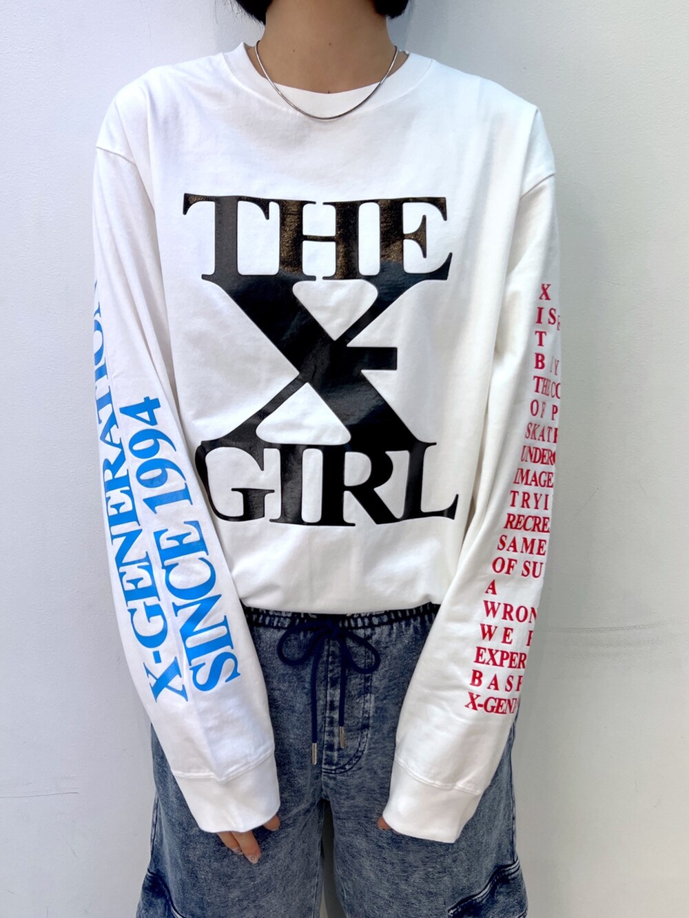 ブルー系のスウェットパンツ、グリーン系のナイロンジャケット、ホワイト系のTシャツ/カットソーを着用したレディースの秋コーディネートの8枚目の写真