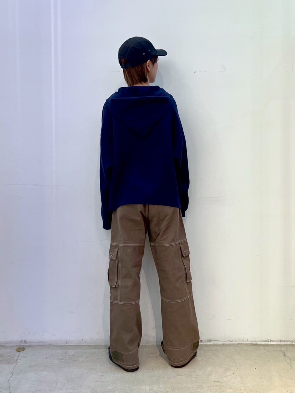 グリーン系のカーゴパンツ、ブルー系のニット/セーター、ブラック系のキャップを着用したレディースの秋コーディネートの2枚目の写真