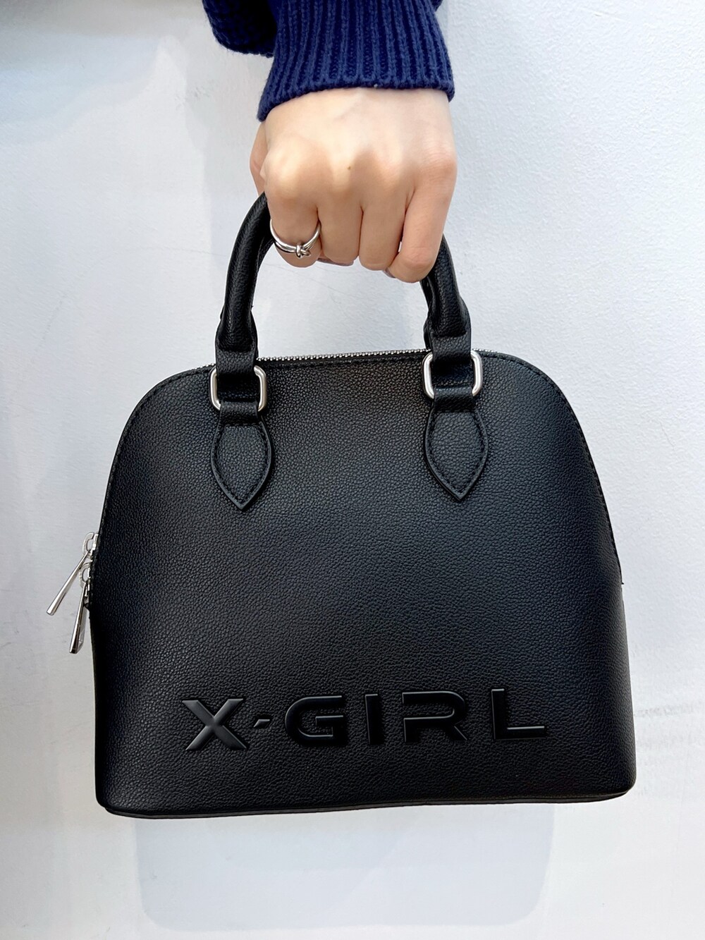 ブルー系のデニムパンツ、ブルー系のニット/セーター、ブラック系のショルダーバッグを着用したレディースの冬コーディネートの7枚目の写真