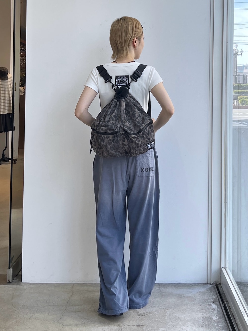ブルー系のその他パンツ、ホワイト系のTシャツ/カットソー、ベージュ系のバックパック/リュックを着用したレディースの夏コーディネートの3枚目の写真