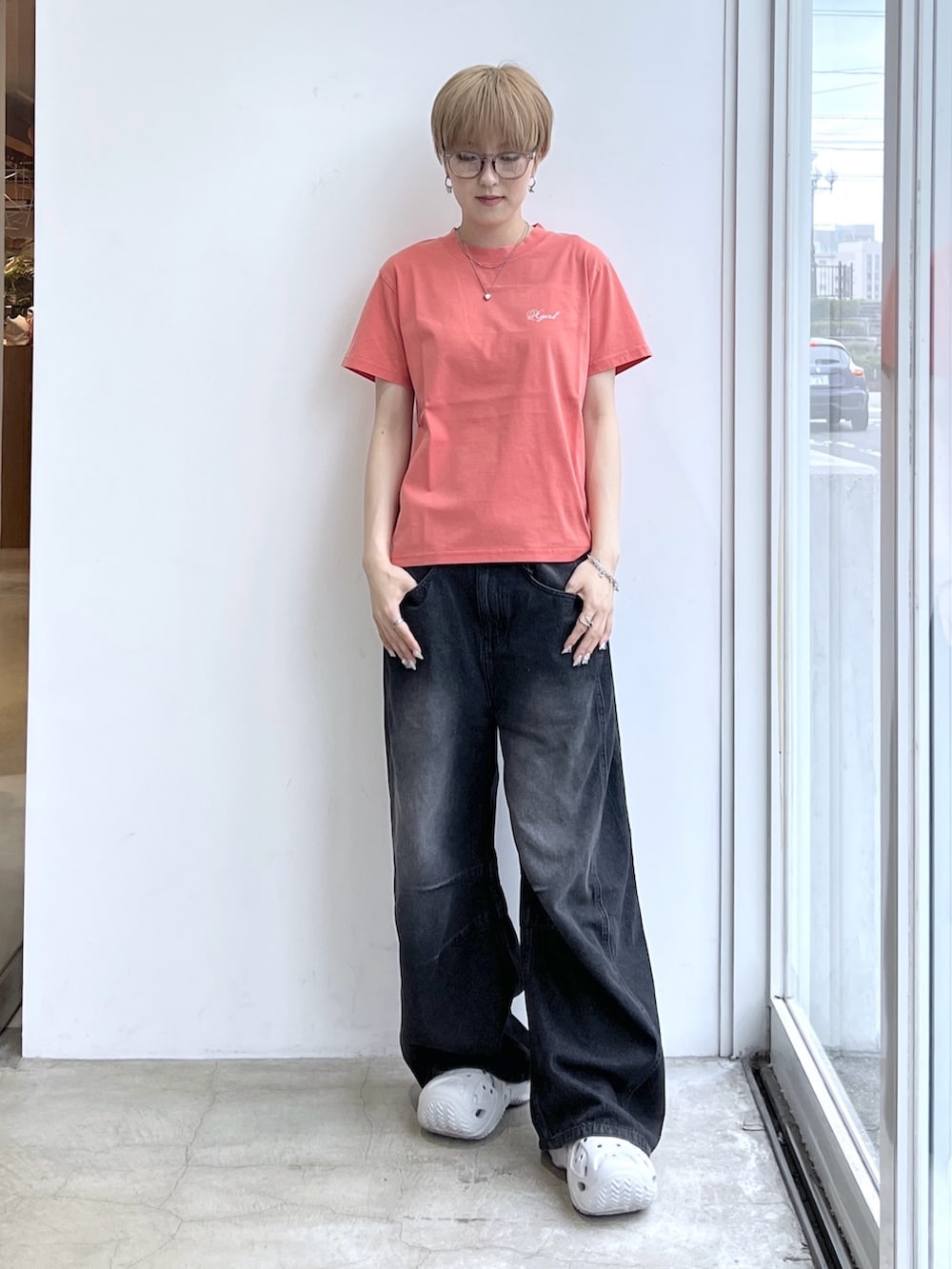 ブラック系のデニムパンツ、オレンジ系のTシャツ/カットソーを着用したレディースの夏コーディネートの2枚目の写真
