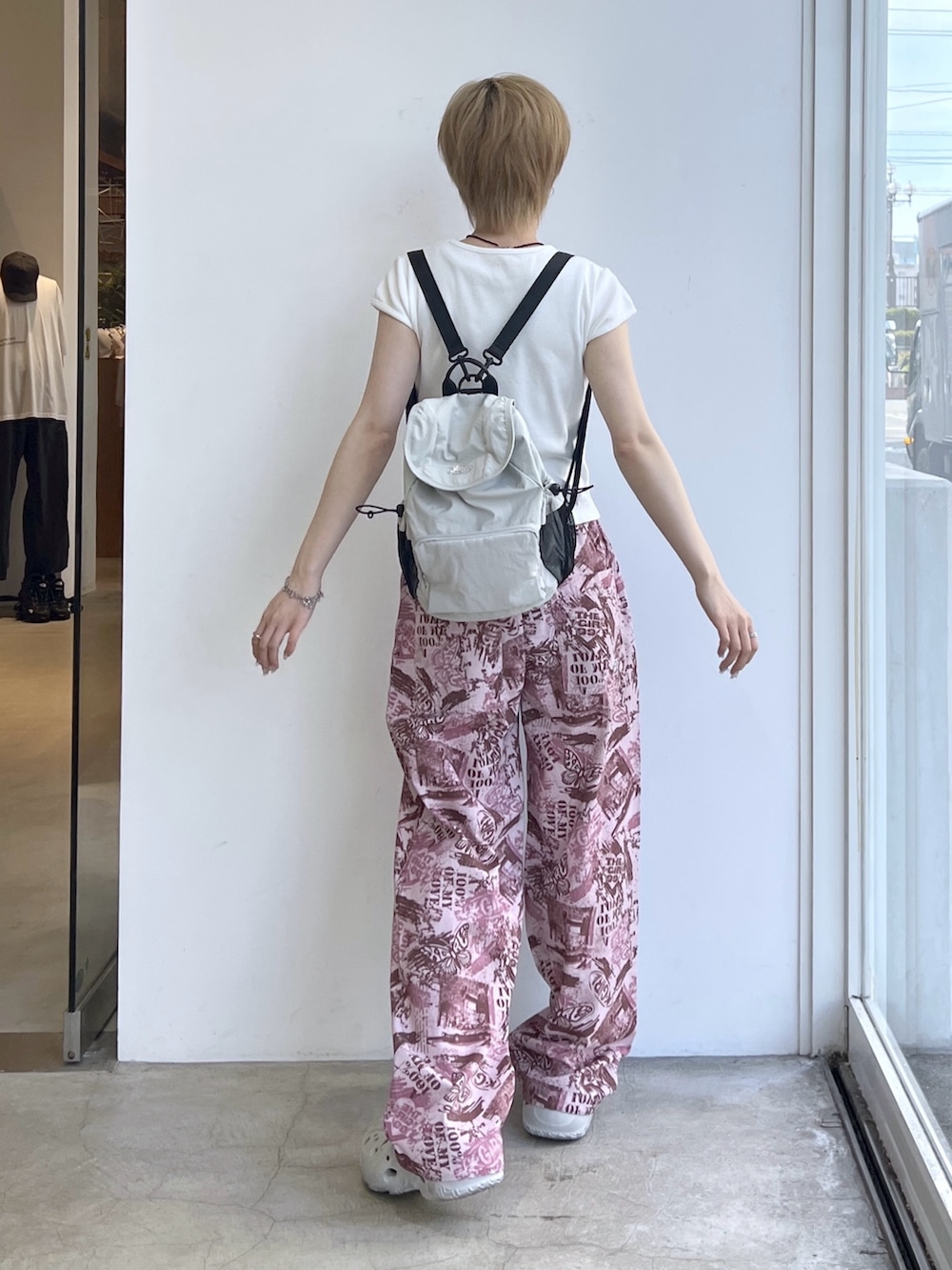 ピンク系のその他パンツ、ホワイト系のTシャツ/カットソー、グレー系のバックパック/リュックを着用したレディースの夏コーディネートの2枚目の写真