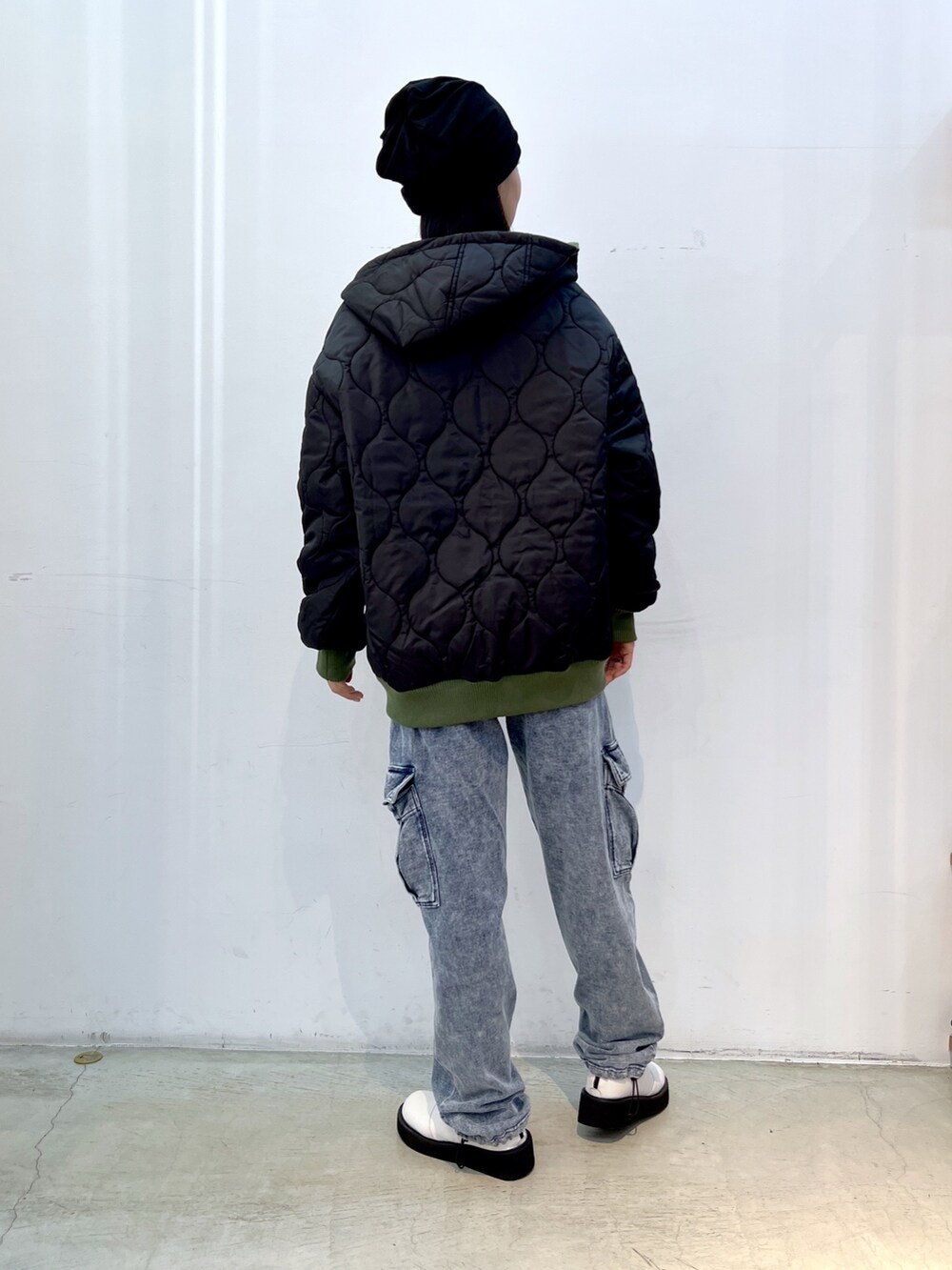 ブルー系のスウェットパンツ、グリーン系のナイロンジャケット、ホワイト系のTシャツ/カットソーを着用したレディースの秋コーディネートの4枚目の写真