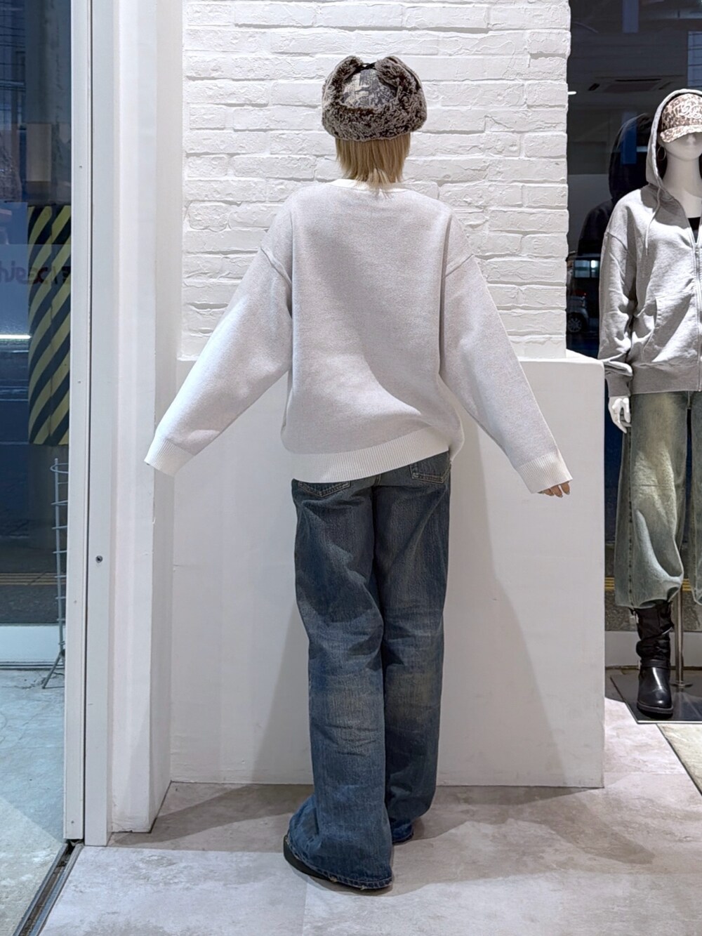 ブルー系のデニムパンツ、ホワイト系のニット/セーター、その他のキャップを着用したレディースの秋コーディネートの2枚目の写真