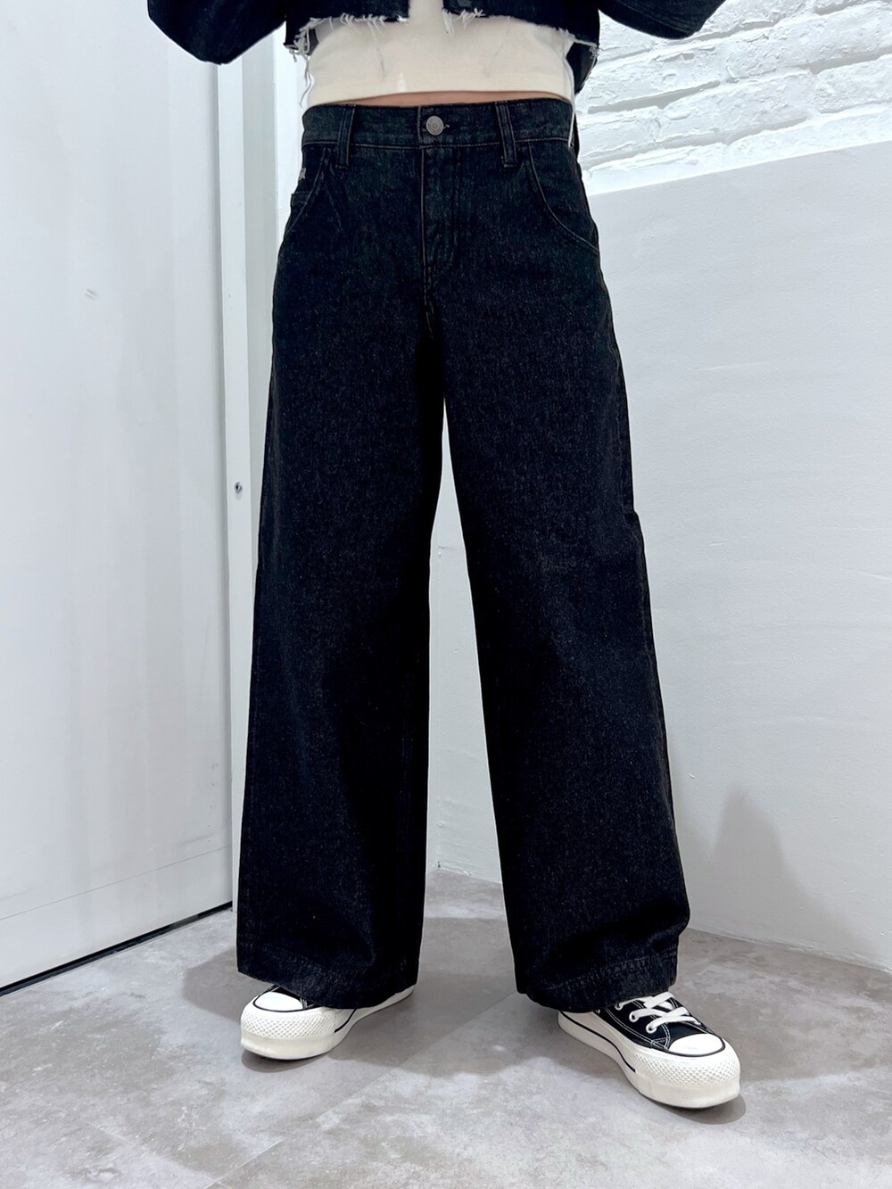 ブラック系のデニムパンツ、ホワイト系のTシャツ/カットソー、ブラック系のデニムジャケットを着用したレディースの冬コーディネートの4枚目の写真