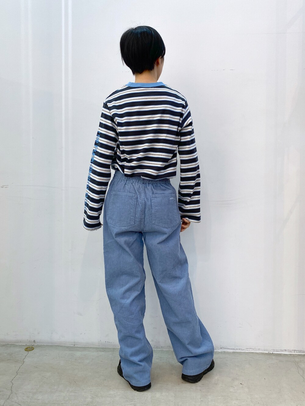 ブルー系のその他パンツ、グレー系のTシャツ/カットソー、ブラック系のショルダーバッグを着用したレディースの冬コーディネートの3枚目の写真