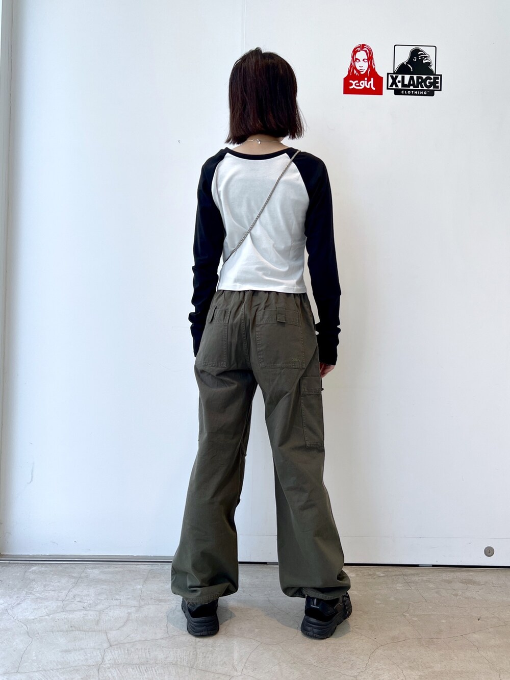 グリーン系のその他パンツ、ブルー系のショルダーバッグ、ホワイト系のTシャツ/カットソーを着用したレディースの秋コーディネートの2枚目の写真