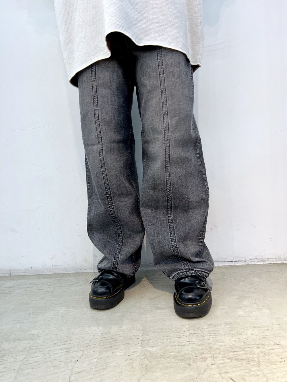 ブラック系のデニムパンツ、ホワイト系のニット/セーター、ブラック系のブルゾンを着用したレディースの冬コーディネートの7枚目の写真