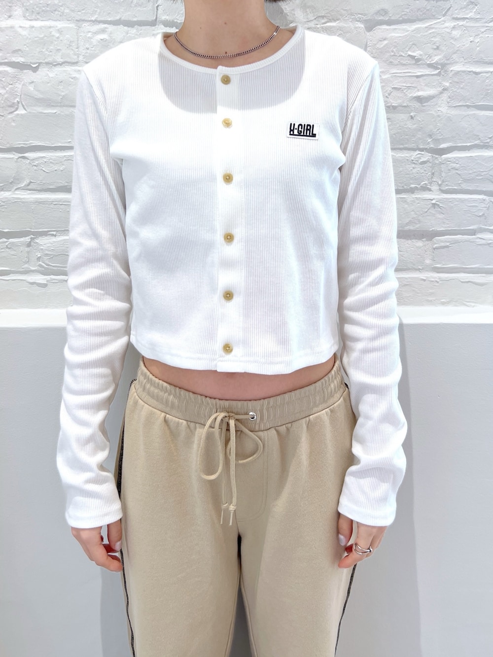 ベージュ系のスウェットパンツ、ホワイト系のカーディガン/ボレロ、ブラック系のキャップを着用したレディースの春コーディネートの3枚目の写真