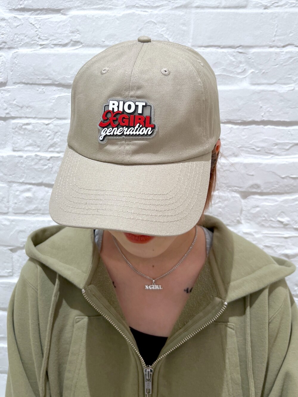 ブルー系のデニムパンツ、グリーン系のパーカー、ベージュ系のキャップを着用したレディースの春コーディネートの6枚目の写真