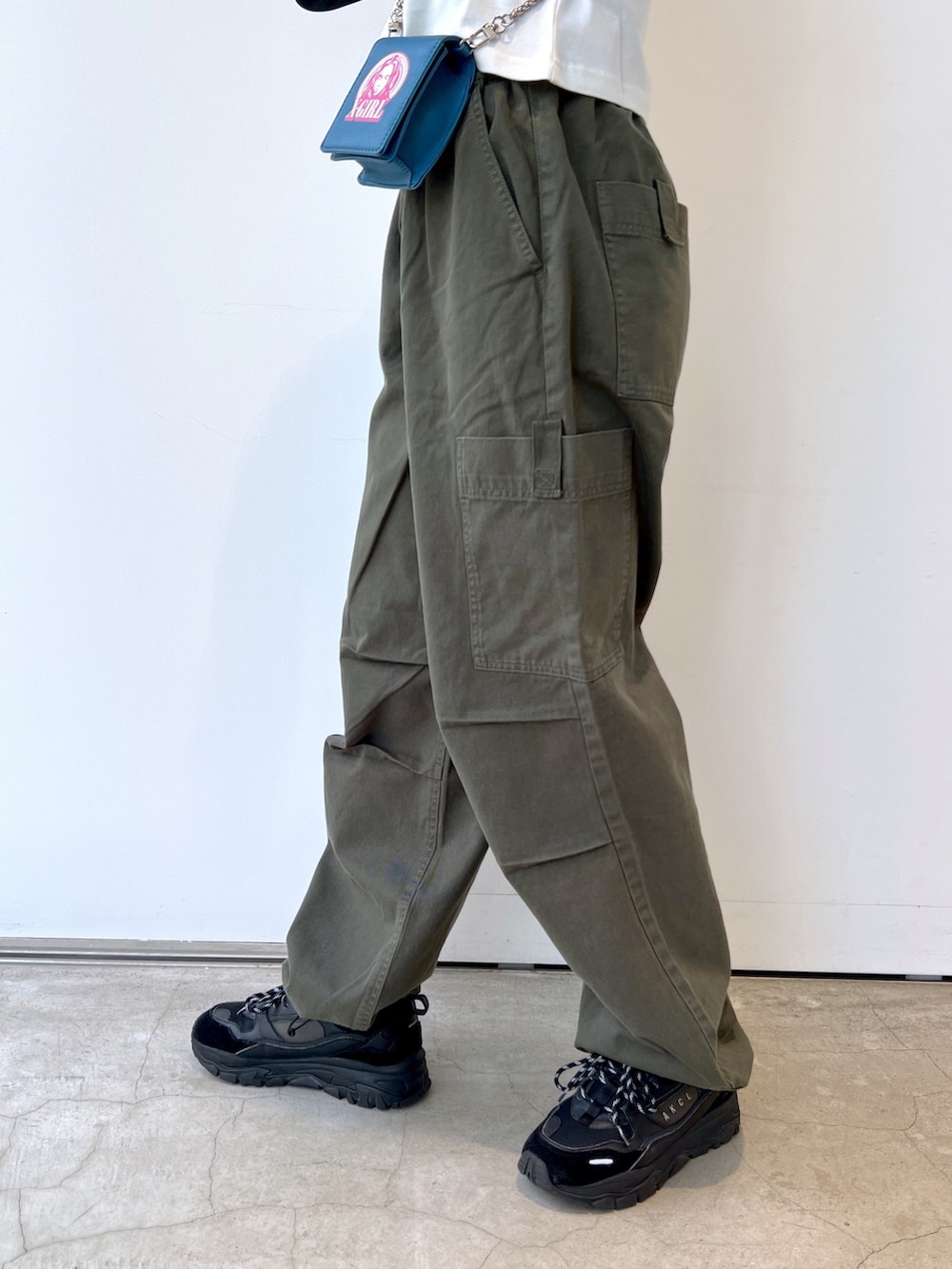 グリーン系のその他パンツ、ブルー系のショルダーバッグ、ホワイト系のTシャツ/カットソーを着用したレディースの秋コーディネートの6枚目の写真