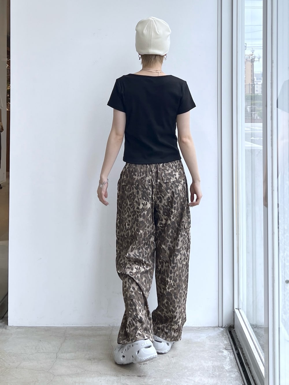 ベージュ系のカーゴパンツ、ブラック系のTシャツ/カットソー、ホワイト系のニットキャップ/ビーニーを着用したレディースの夏コーディネートの2枚目の写真