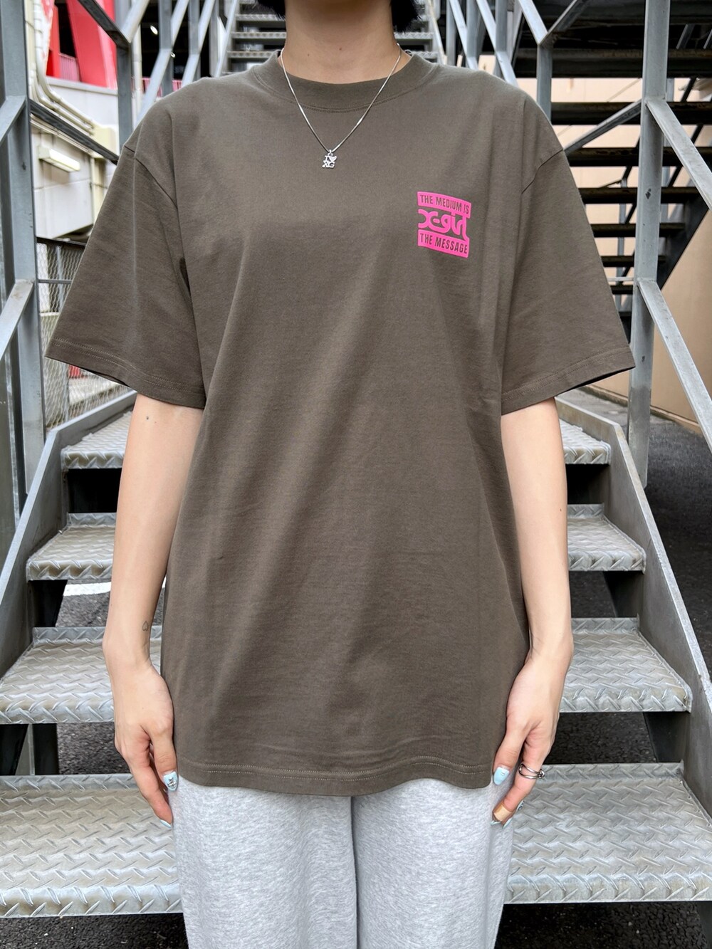 グレー系のスウェットパンツ、グリーン系のTシャツ/カットソー、ブラック系のニットキャップ/ビーニーを着用したレディースの夏コーディネートの3枚目の写真