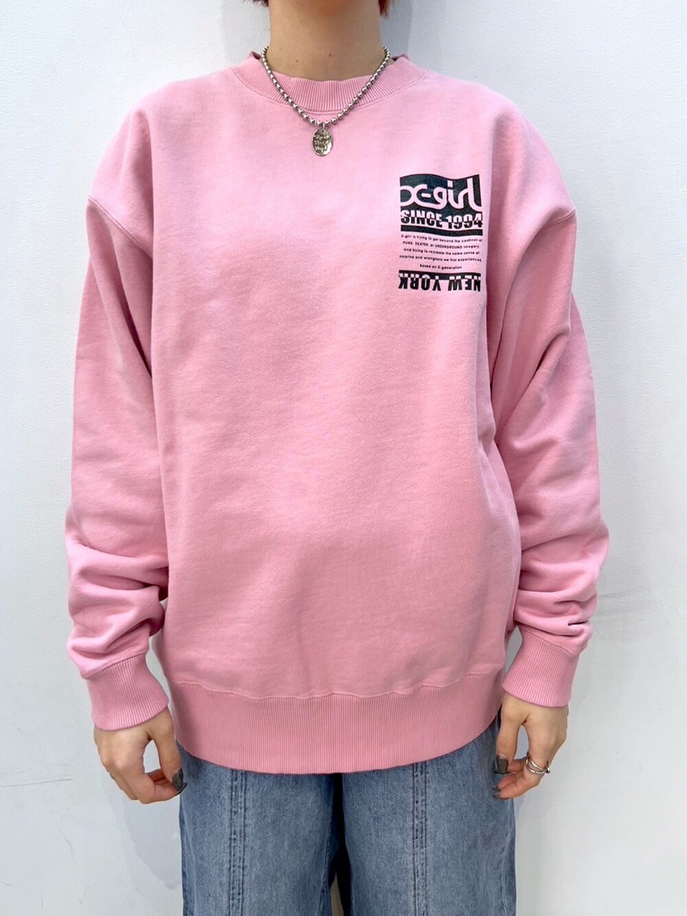 ピンク系のスウェット、ブルー系のデニムパンツ、ブラック系のニットキャップ/ビーニーを着用したレディースの冬コーディネートの3枚目の写真