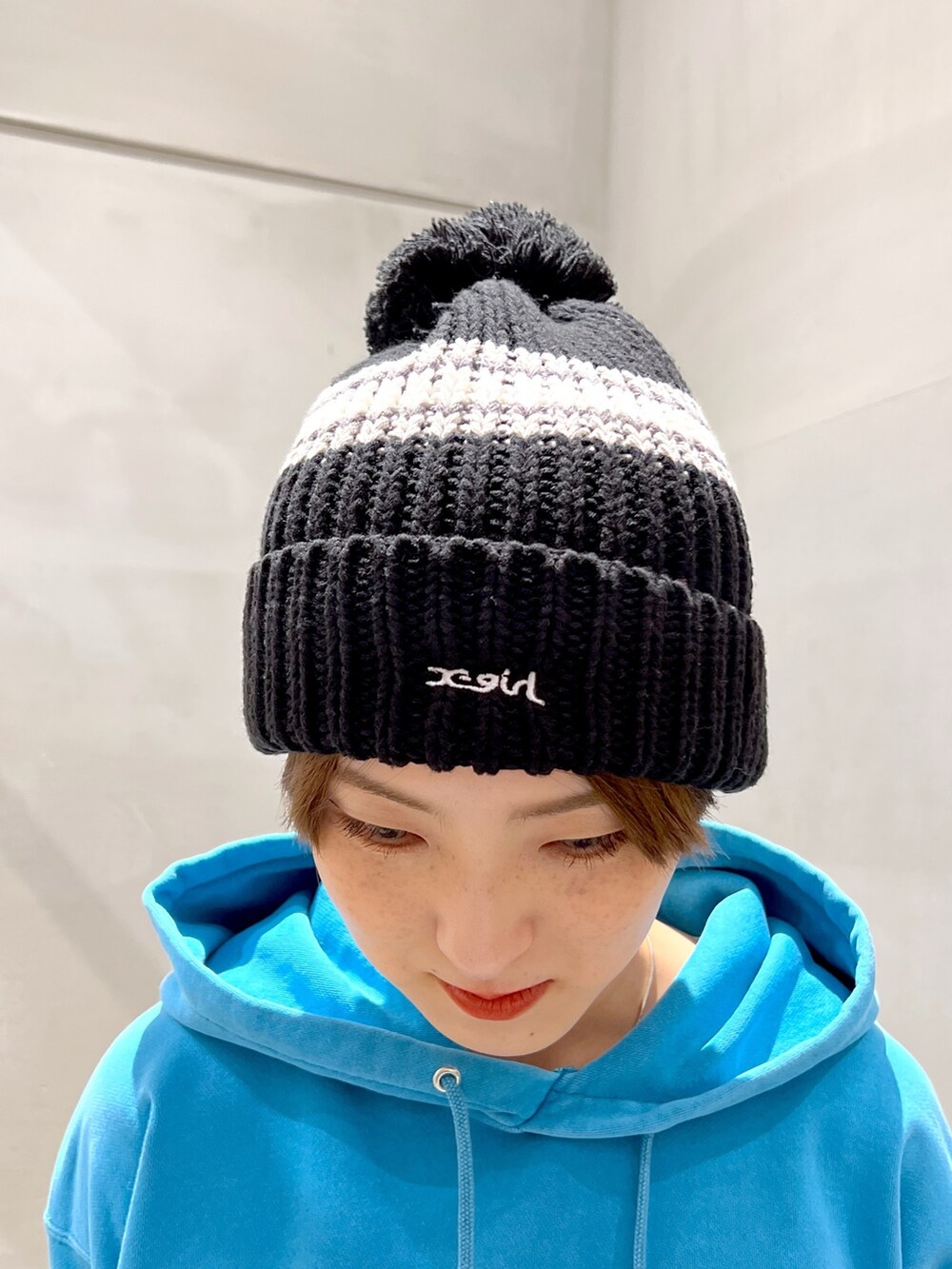 ブルー系のパーカー、ブラック系のショルダーバッグ、グレー系のスウェットパンツを着用したレディースの秋コーディネートの6枚目の写真