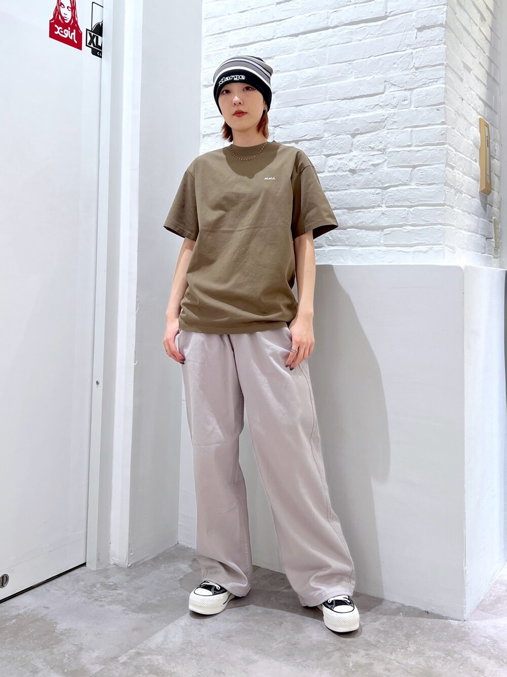 グレー系のその他パンツ、グリーン系のTシャツ/カットソー、ブラック系のニットキャップ/ビーニーを着用したレディースの春コーディネートの2枚目の写真