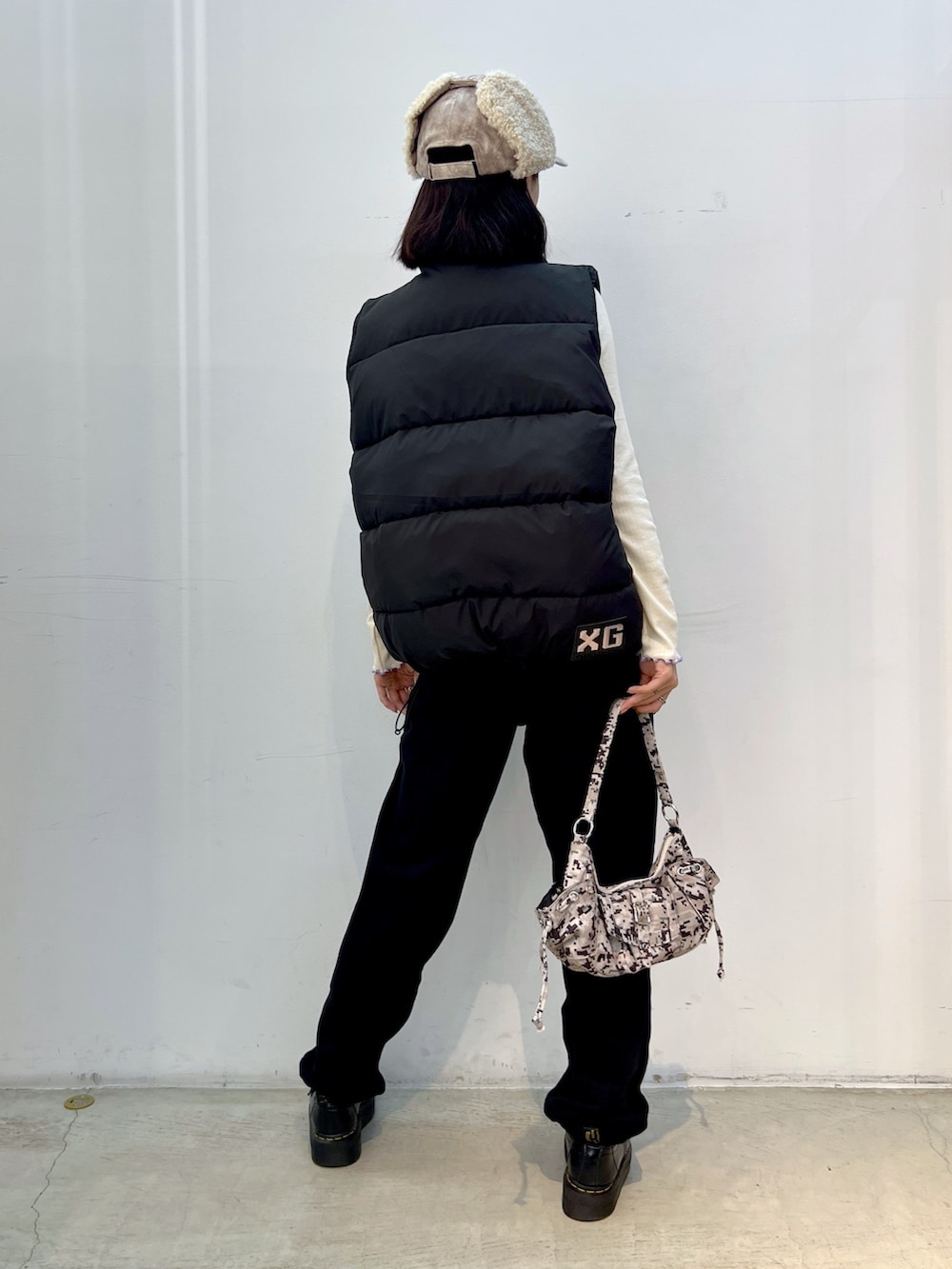 ブラック系のスウェットパンツ、ブラック系のダウンベスト、ホワイト系のTシャツ/カットソーを着用したレディースの秋コーディネートの2枚目の写真