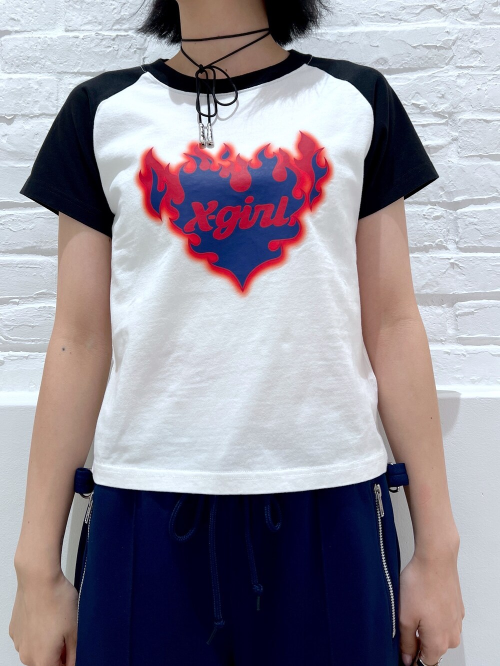 ブラック系のショルダーバッグ、ブルー系のその他パンツ、ホワイト系のTシャツ/カットソーを着用したレディースの夏コーディネートの3枚目の写真