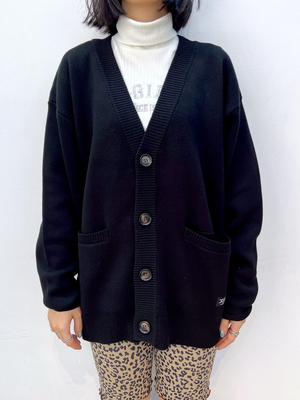 ブラック系のカーディガン/ボレロ、ホワイト系のTシャツ/カットソー、ピンク系のショルダーバッグを着用したレディースの秋コーディネートの3枚目の写真