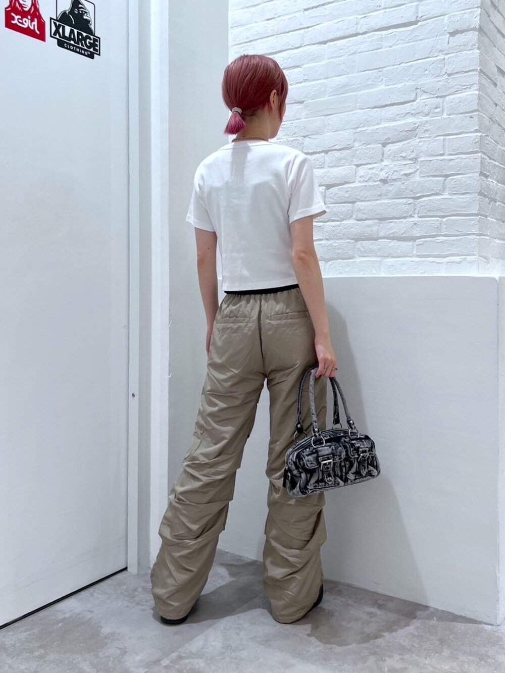 ベージュ系のその他パンツ、ブラック系のハンドバッグ、ホワイト系のTシャツ/カットソーを着用したレディースの春コーディネートの2枚目の写真