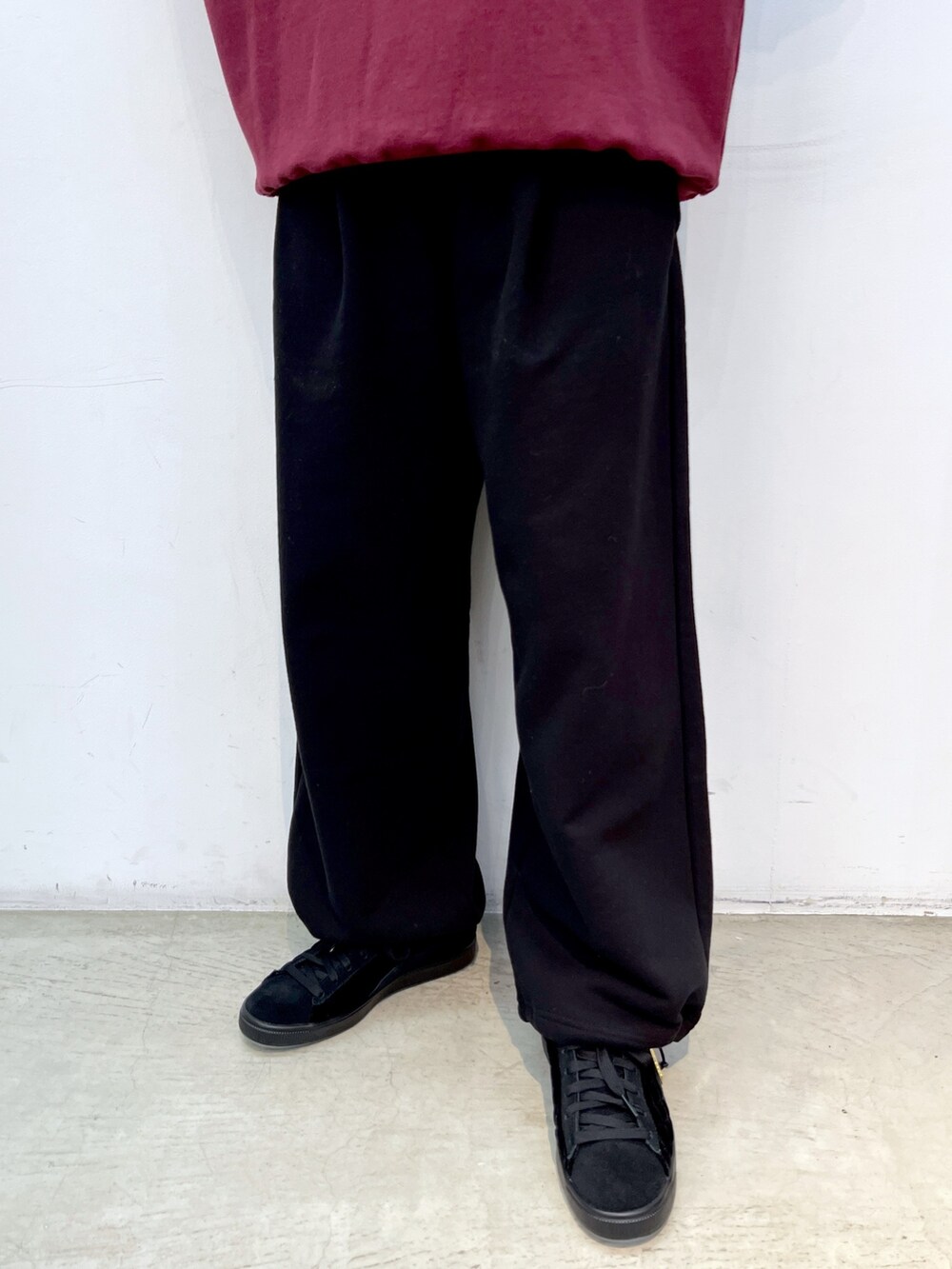 レッド系のスウェット、ブラック系のスウェットパンツ、ブラック系のスニーカーを着用したレディースの秋コーディネートの5枚目の写真