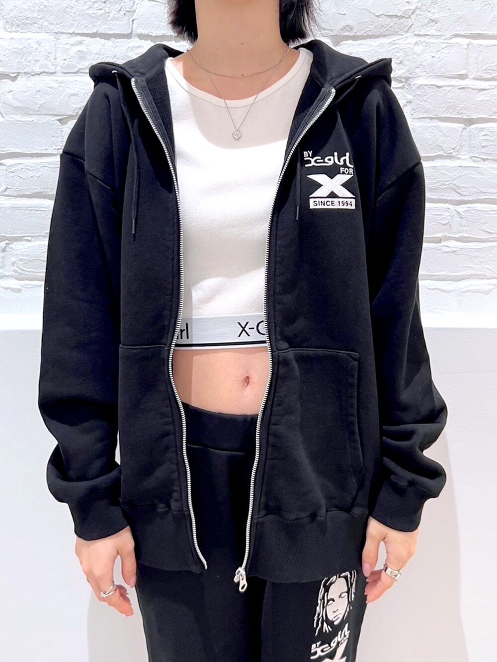 ブラック系のスウェットパンツ、ホワイト系のTシャツ/カットソー、ブラック系のパーカーを着用したレディースの秋コーディネートの3枚目の写真