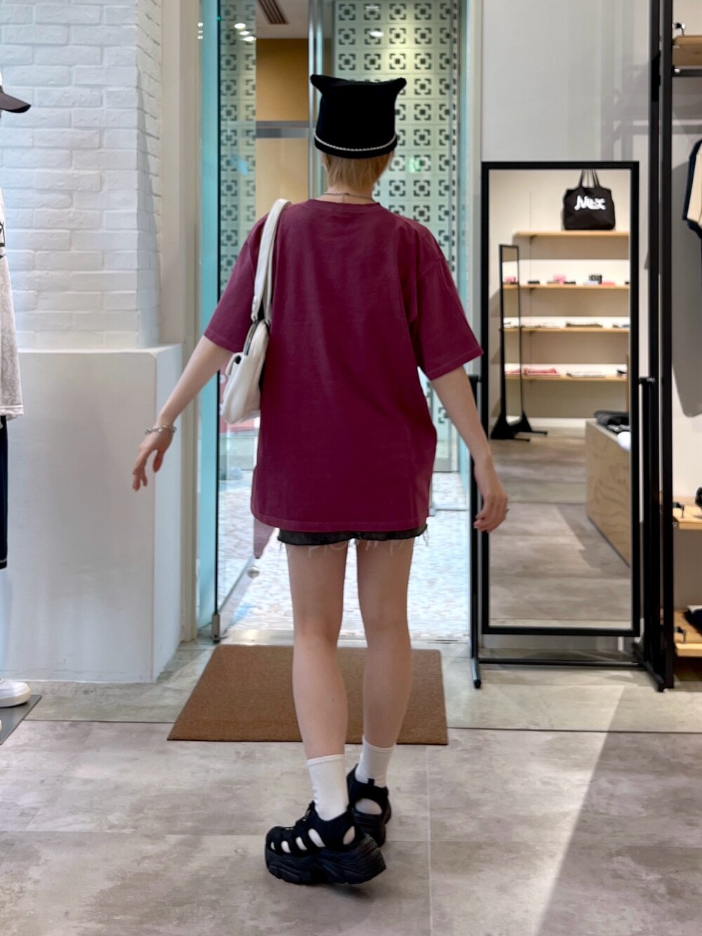 ホワイト系のハンドバッグ、ブラック系のデニムスカート、レッド系のTシャツ/カットソーを着用したレディースの夏コーディネートの3枚目の写真