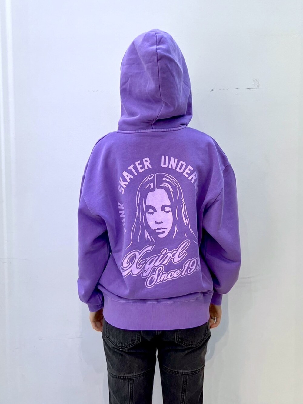 ブラック系のデニムパンツ、パープル系のパーカー、グレー系のショルダーバッグを着用したレディースの冬コーディネートの4枚目の写真