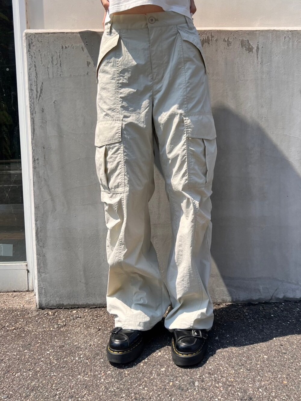 グレー系のカーゴパンツ、ホワイト系のTシャツ/カットソー、グレー系のキャップを着用したレディースの夏コーディネートの4枚目の写真