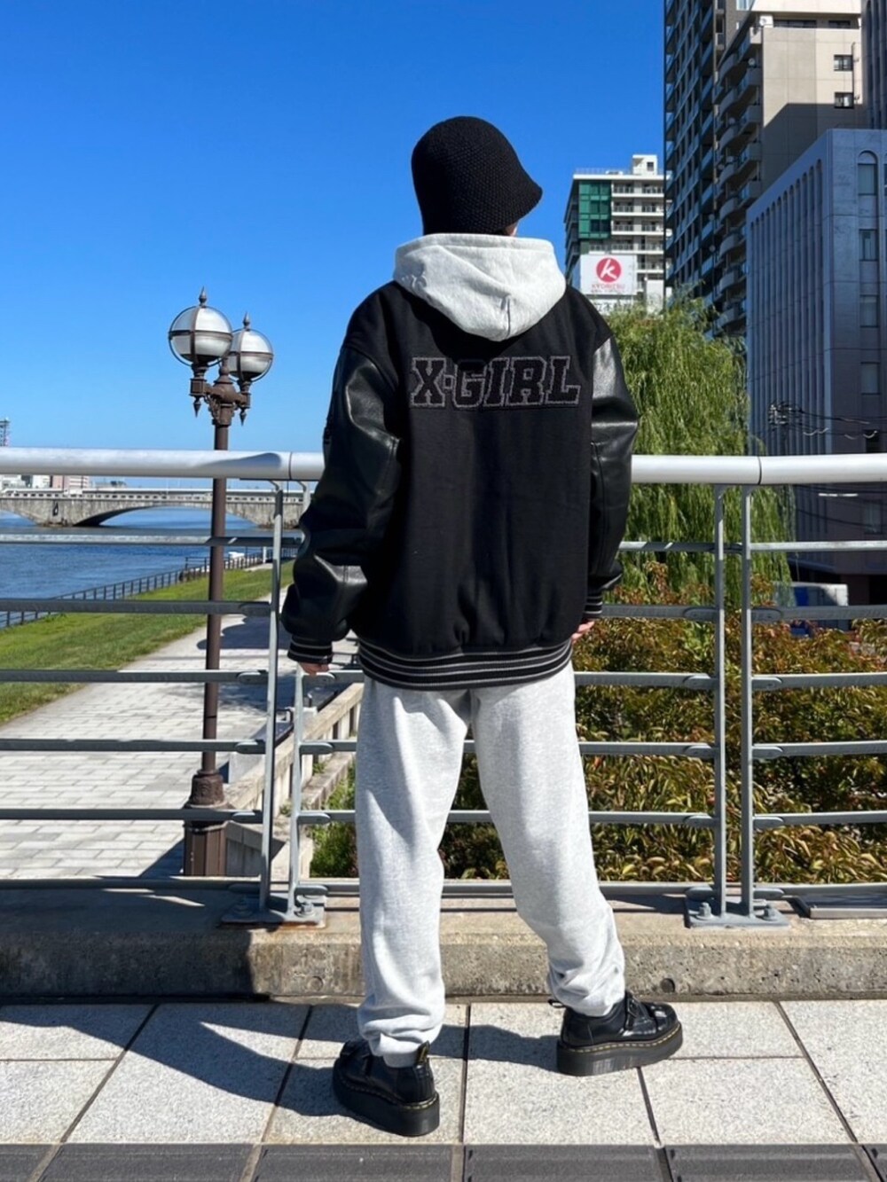 グレー系のスウェットパンツ、グレー系のパーカー、ブラック系のスタジャンを着用したレディースの秋コーディネートの2枚目の写真