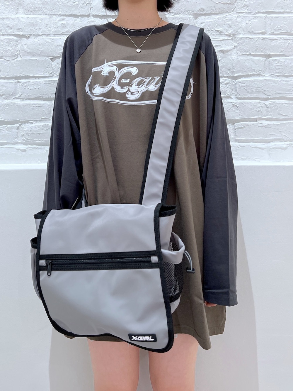 グリーン系のワンピース、グレー系のショルダーバッグ、ホワイト系のハットを着用したレディースの夏コーディネートの3枚目の写真