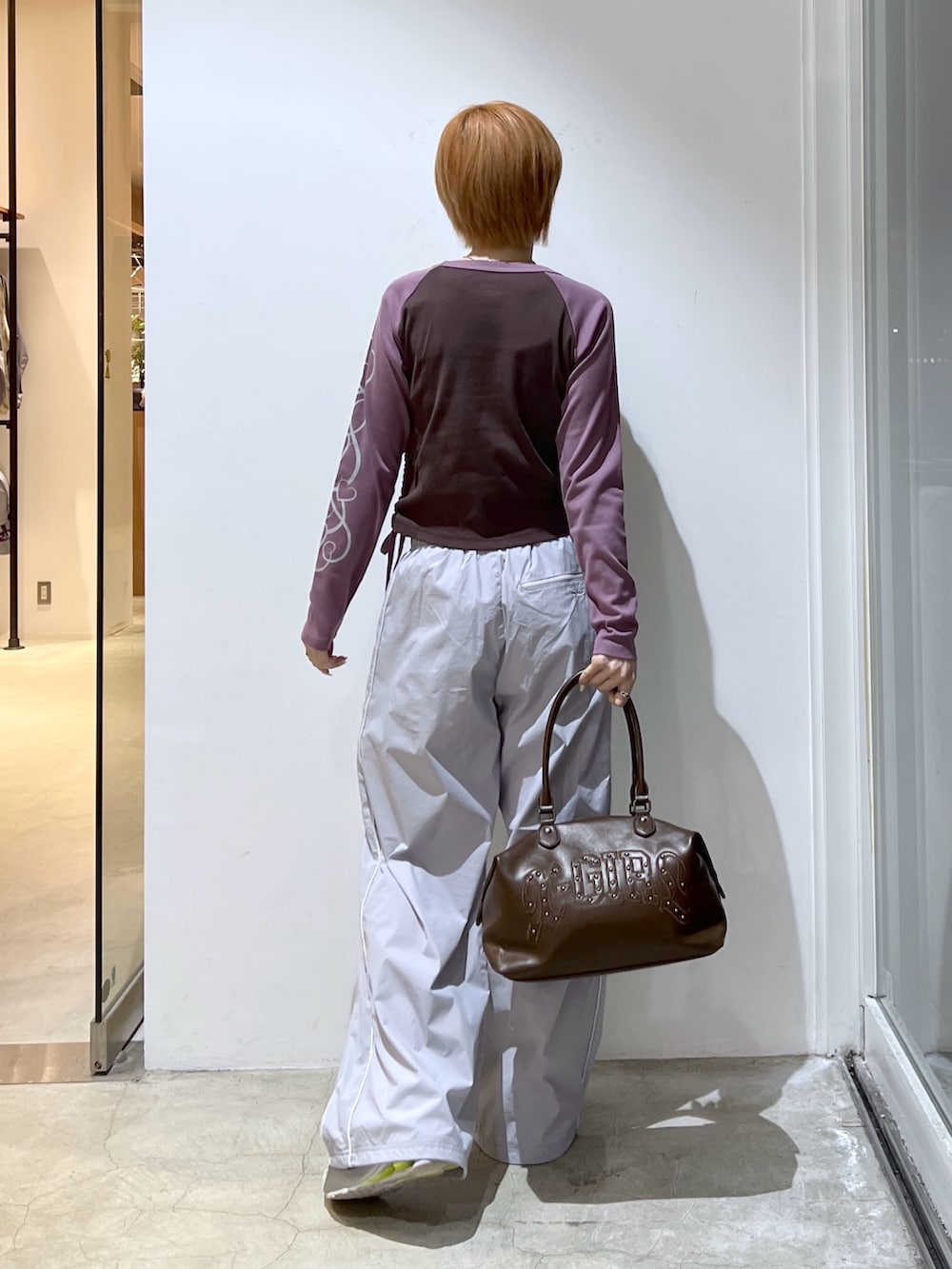 ブラウン系のショルダーバッグ、グレー系のその他パンツ、ブラウン系のTシャツ/カットソーを着用したレディースの冬コーディネートの2枚目の写真
