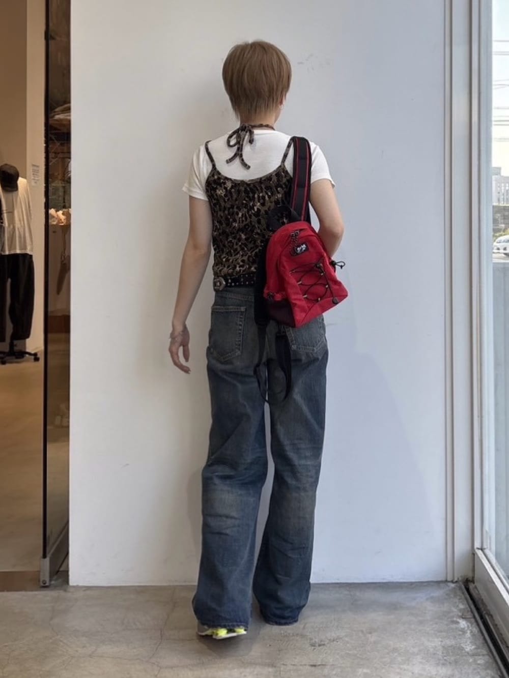 ブルー系のデニムパンツ、ベージュ系のキャミソール、ホワイト系のTシャツ/カットソーを着用したレディースの春コーディネートの2枚目の写真