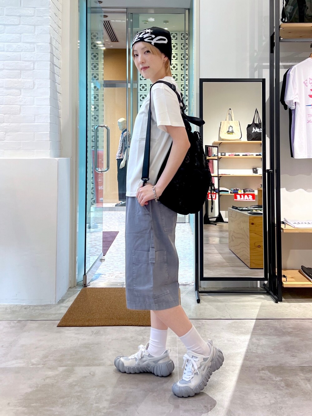 グレー系のその他パンツ、ホワイト系のTシャツ/カットソー、ブラック系のバックパック/リュックを着用したレディースの夏コーディネートの2枚目の写真