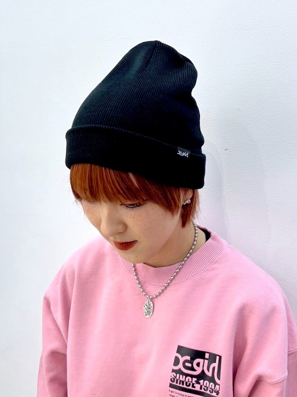 ピンク系のスウェット、ブルー系のデニムパンツ、ブラック系のニットキャップ/ビーニーを着用したレディースの冬コーディネートの6枚目の写真