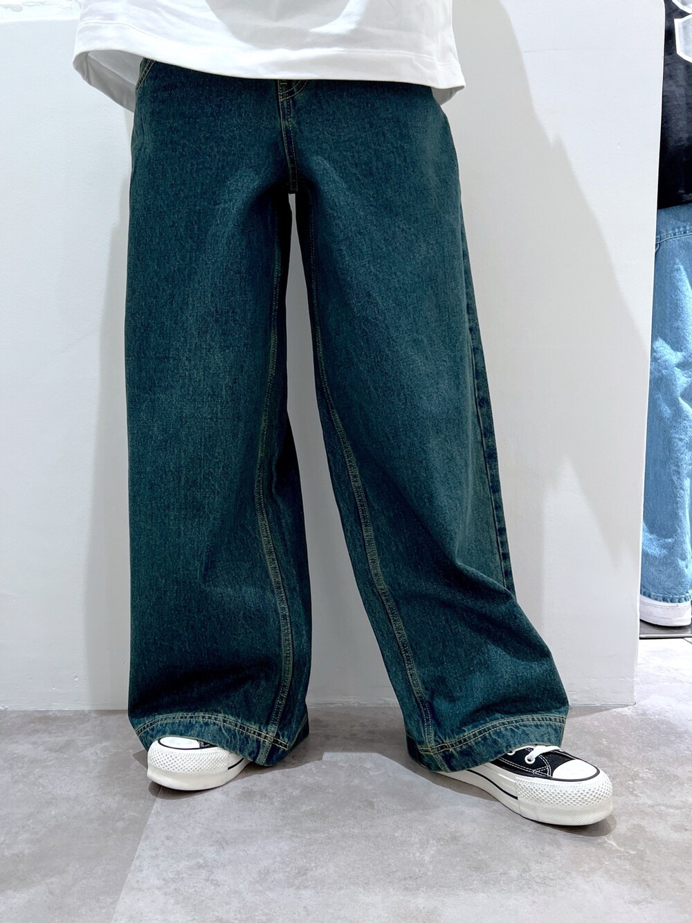 ブルー系のデニムパンツ、ホワイト系のTシャツ/カットソー、ベージュ系のハットを着用したレディースの春コーディネートの5枚目の写真