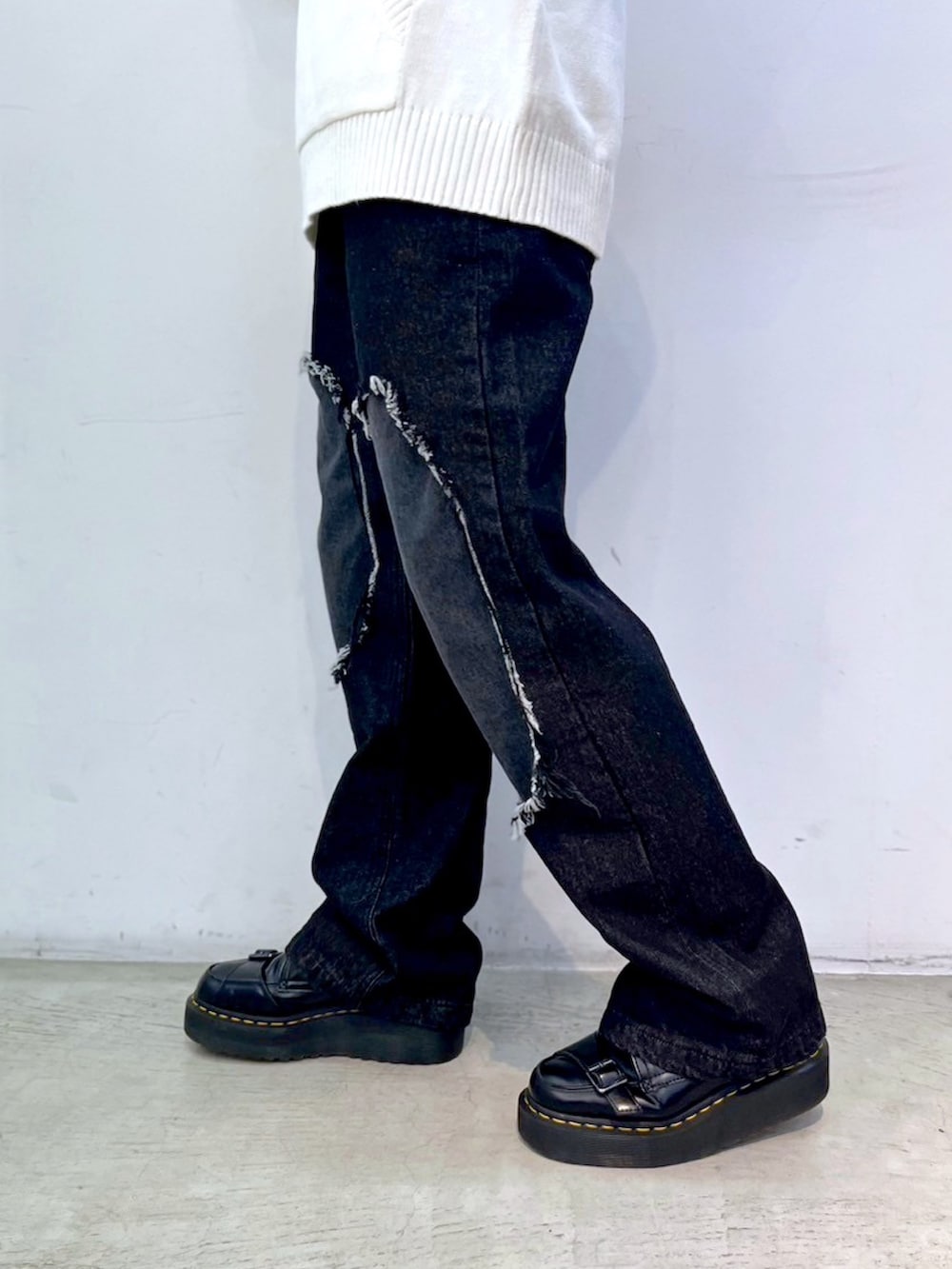ブラック系のデニムパンツ、ピンク系のショルダーバッグ、ホワイト系のニット/セーターを着用したレディースの冬コーディネートの5枚目の写真