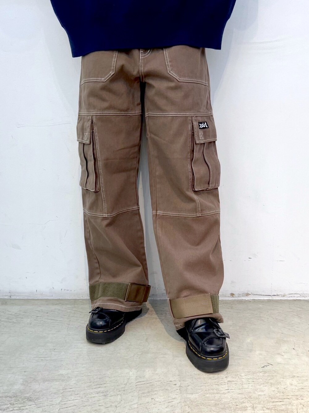 グリーン系のカーゴパンツ、ブルー系のニット/セーター、ブラック系のキャップを着用したレディースの秋コーディネートの4枚目の写真