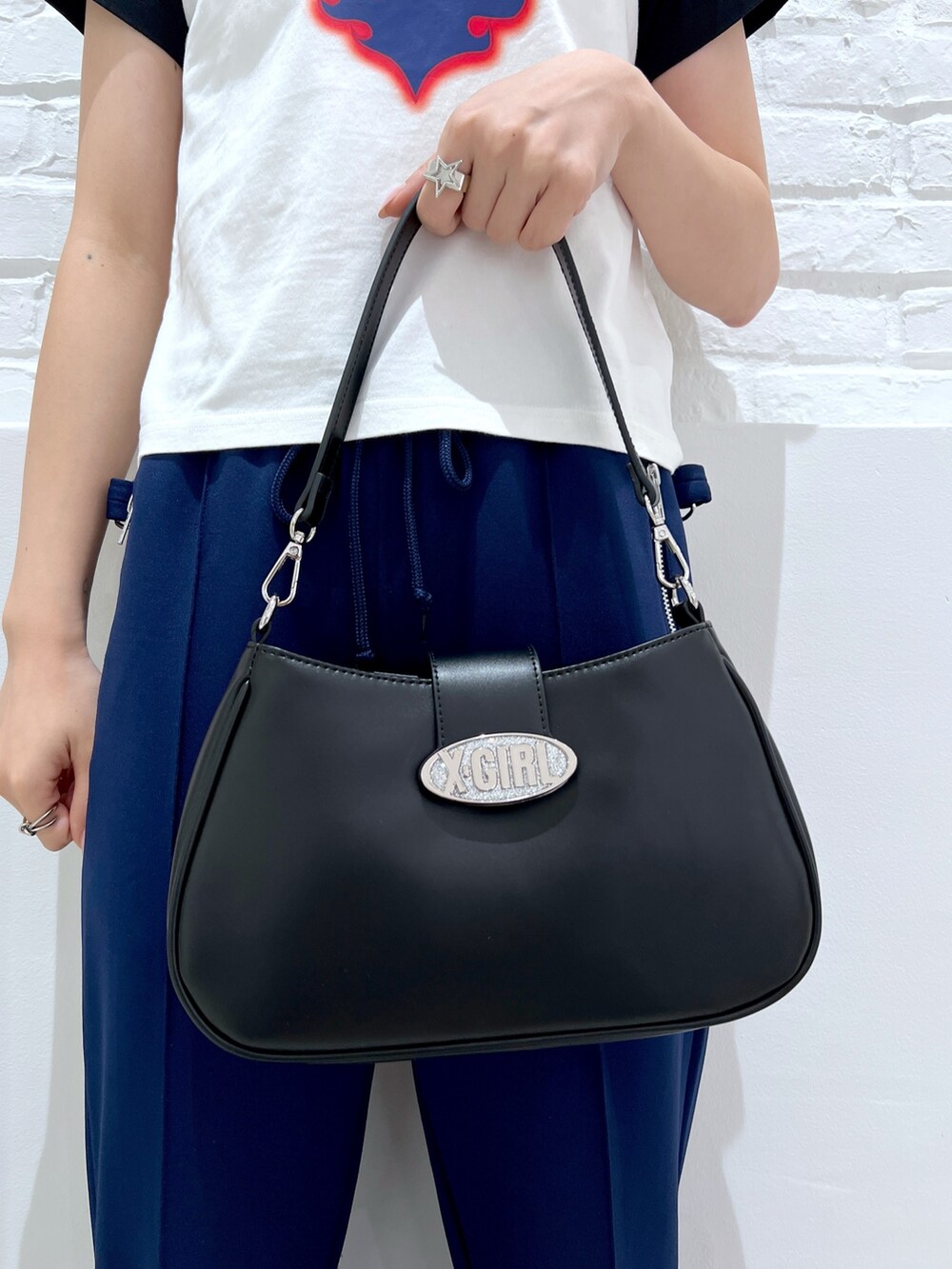 ブラック系のショルダーバッグ、ブルー系のその他パンツ、ホワイト系のTシャツ/カットソーを着用したレディースの夏コーディネートの7枚目の写真